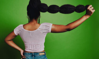 Shot Of A Young Woman Posing Against A Green Background With A Trendy Hairstyle