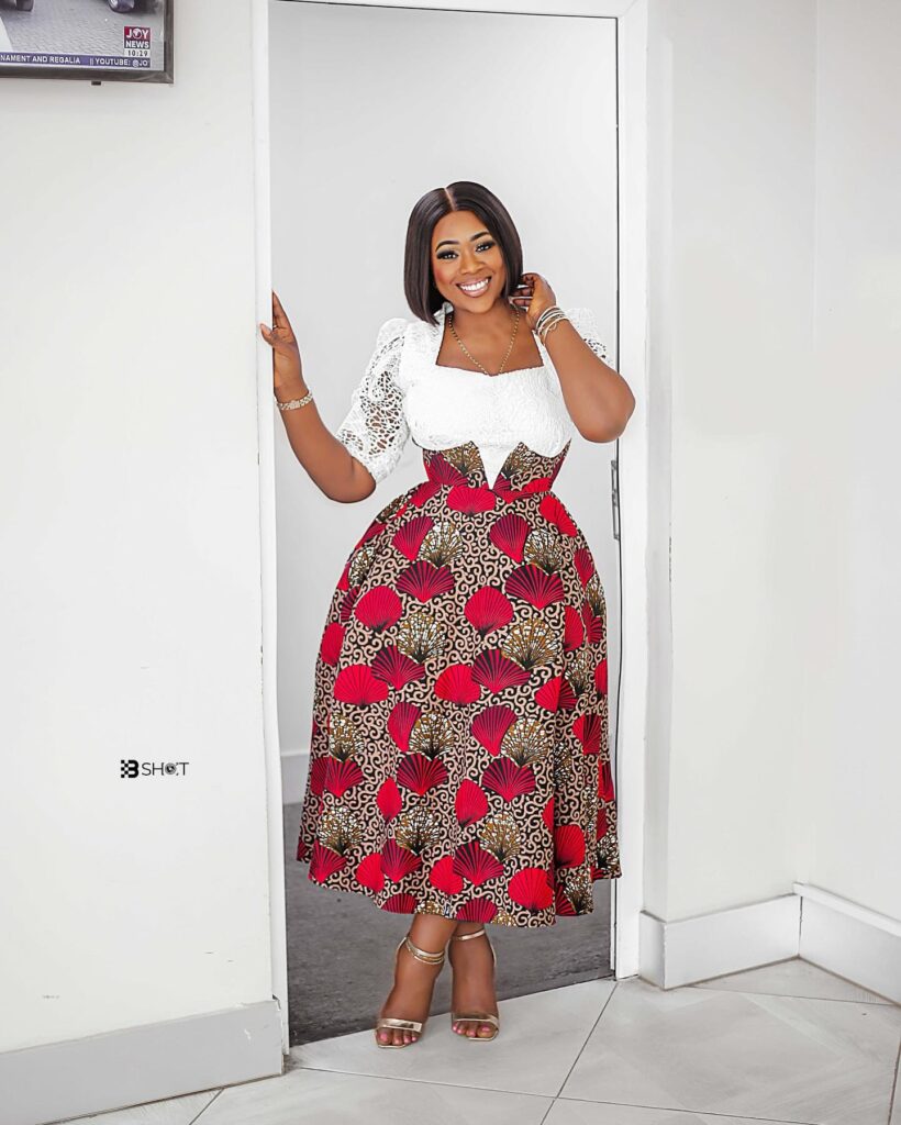 A white lace blouse with a high-waisted, patterned skirt.